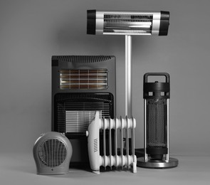 Photo of Different types of electric heaters on grey background
