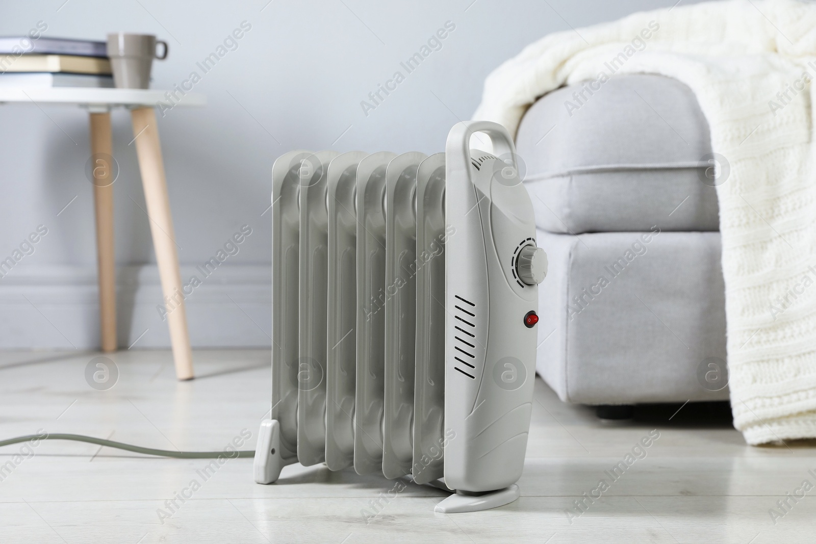 Photo of Electric heater on light wooden floor indoors