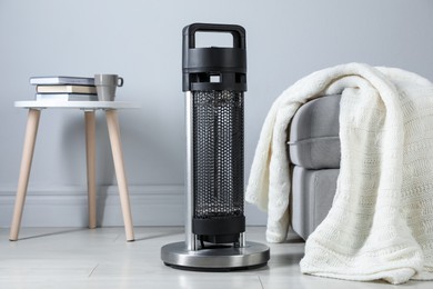 Photo of Electric heater on light wooden floor indoors