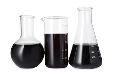 Photo of Different laboratory glassware with black liquid isolated on white