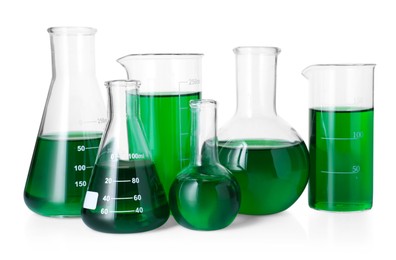 Photo of Different laboratory glassware with green liquid isolated on white