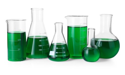 Photo of Different laboratory glassware with green liquid isolated on white