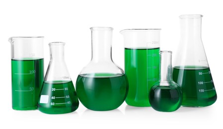 Photo of Different laboratory glassware with green liquid isolated on white