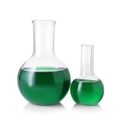 Photo of Different laboratory glassware with green liquid isolated on white