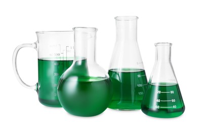 Photo of Different laboratory glassware with green liquid isolated on white
