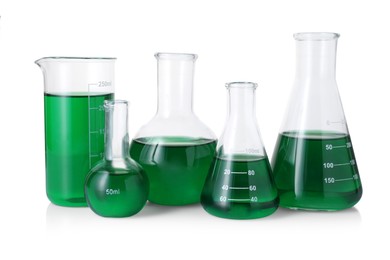 Photo of Different laboratory glassware with green liquid isolated on white