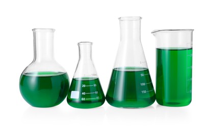 Photo of Different laboratory glassware with green liquid isolated on white