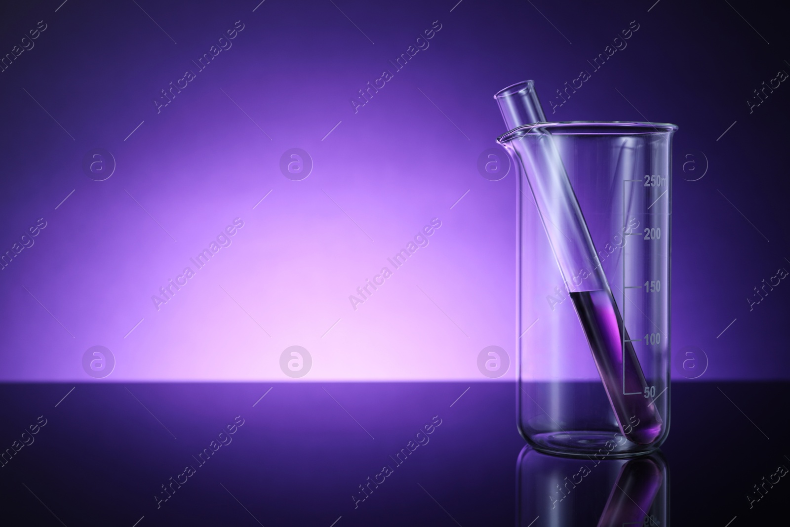 Photo of Beaker and test tube with color liquid on table against violet background. Space for text