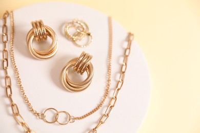 Photo of Beautiful gold jewelry on beige background, top view