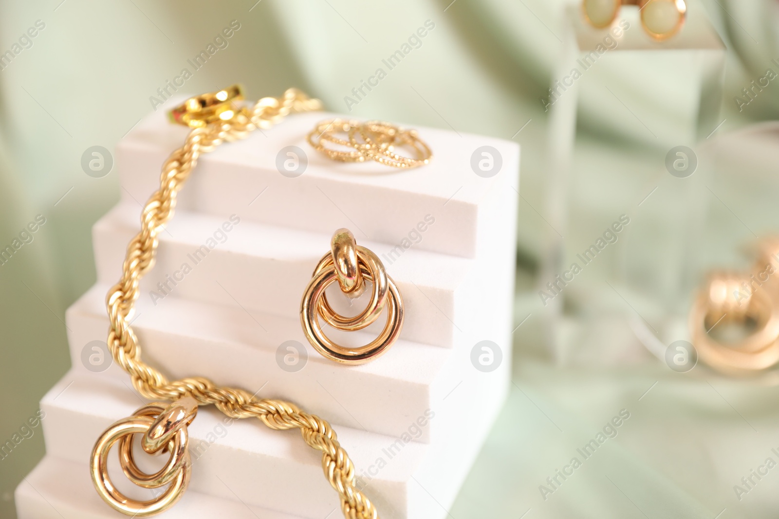 Photo of Stylish presentation of beautiful gold jewelry on silk cloth, closeup