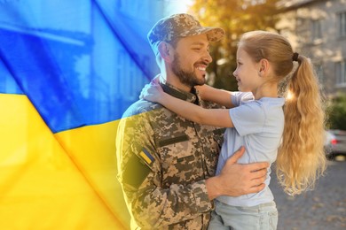 Image of Military man and his happy daughter outdoors. Double exposure with flag of Ukraine