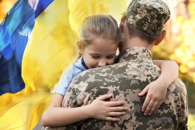 Image of Military man and his happy daughter outdoors. Double exposure with flag of Ukraine