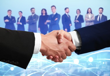 Image of Business partners shaking hands against group of people. Cityscape on background