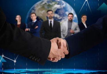 Image of Business partners shaking hands against group of people. Globe and graph on background