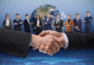 Image of Business partners shaking hands against group of people. Globe on background