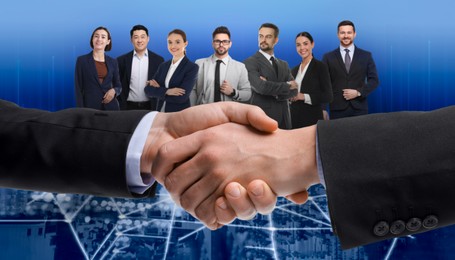 Image of Business partners shaking hands against group of people. Blue gradient background