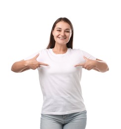 Photo of Smiling woman pointing at her stylish t-shirt on white background. Mockup for design