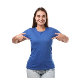 Photo of Smiling woman pointing at her blue t-shirt on white background. Mockup for design