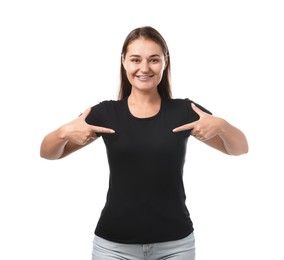 Photo of Smiling woman pointing at her black t-shirt on white background. Mockup for design