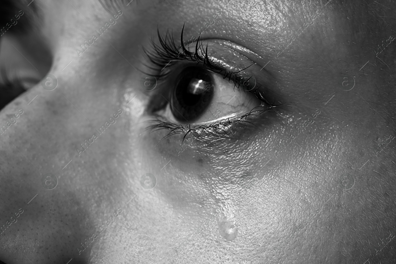 Photo of Closeup view of sad woman crying. Black and white effect