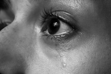 Photo of Closeup view of sad woman crying. Black and white effect