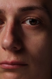 Photo of Closeup view of sad young woman crying