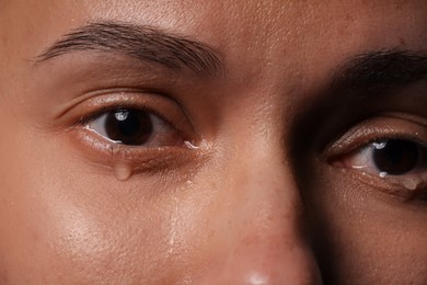 Photo of Closeup view of sad young woman crying