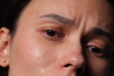 Photo of Closeup view of sad young woman crying