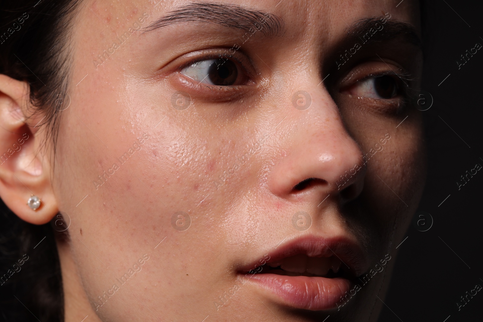 Photo of Sad woman crying on black background, closeup