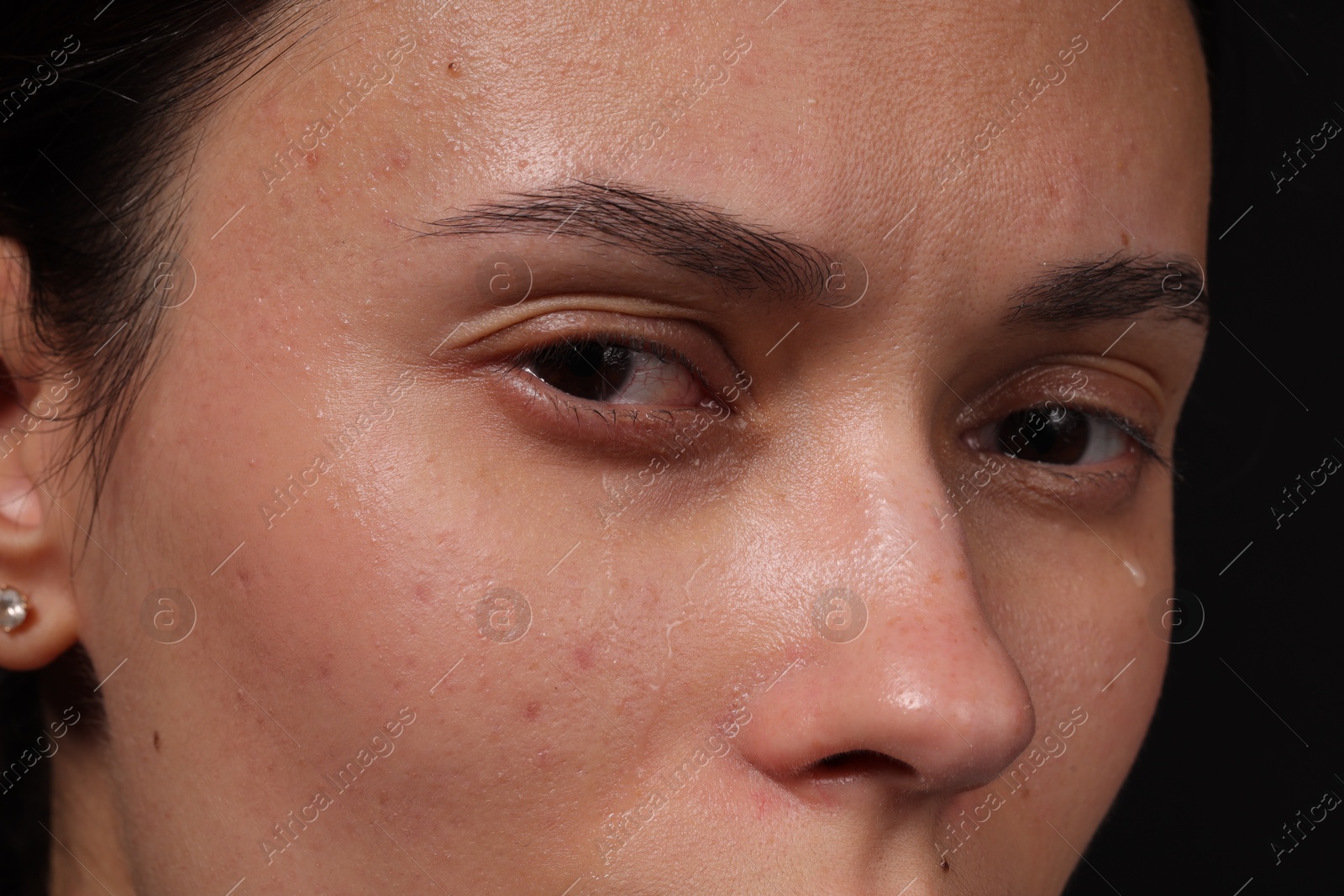 Photo of Sad woman crying on black background, closeup
