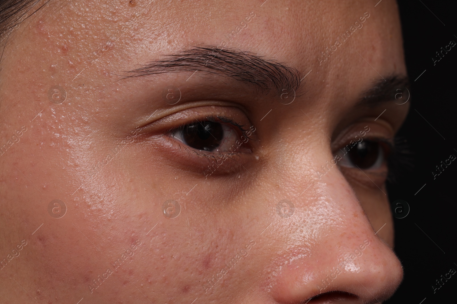 Photo of Sad woman crying on black background, closeup