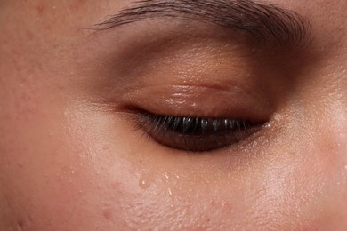 Photo of Closeup view of sad young woman crying