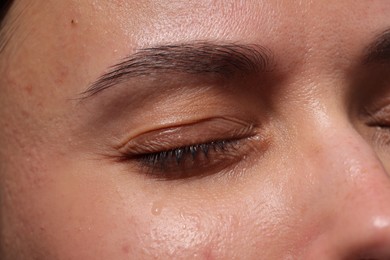Photo of Closeup view of sad young woman crying