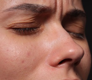 Photo of Closeup view of sad young woman crying