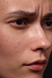 Photo of Closeup view of sad young woman crying