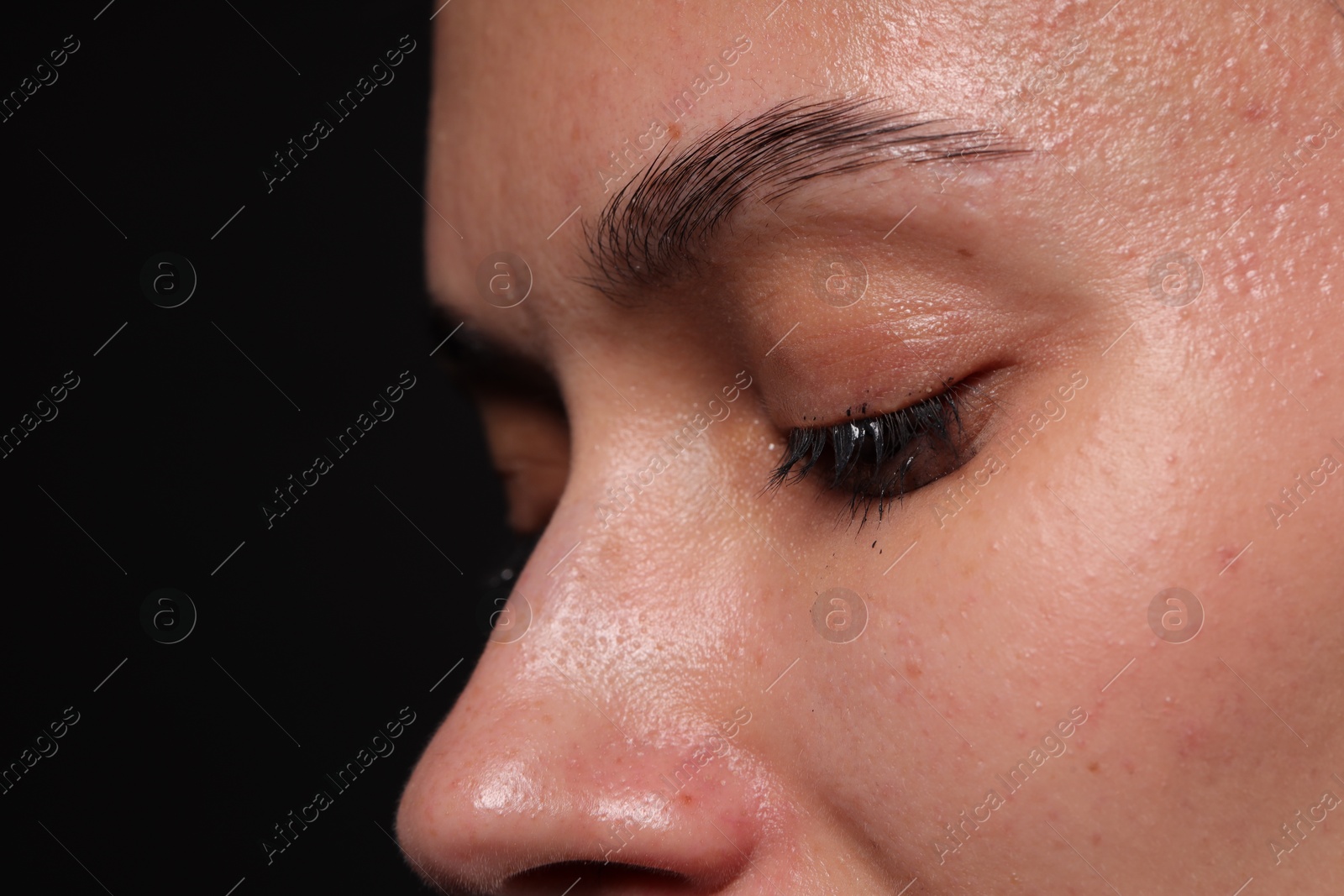 Photo of Sad woman crying on black background, closeup. Space for text