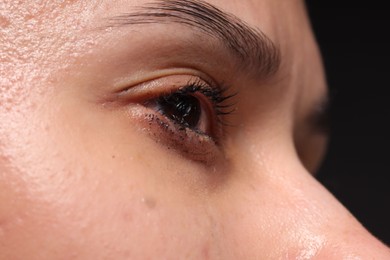 Photo of Sad woman crying on black background, closeup