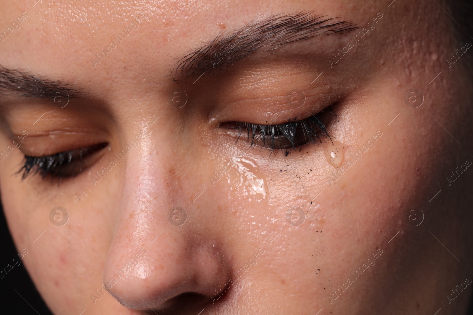Photo of Closeup view of sad young woman crying