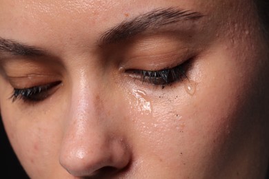 Photo of Closeup view of sad young woman crying