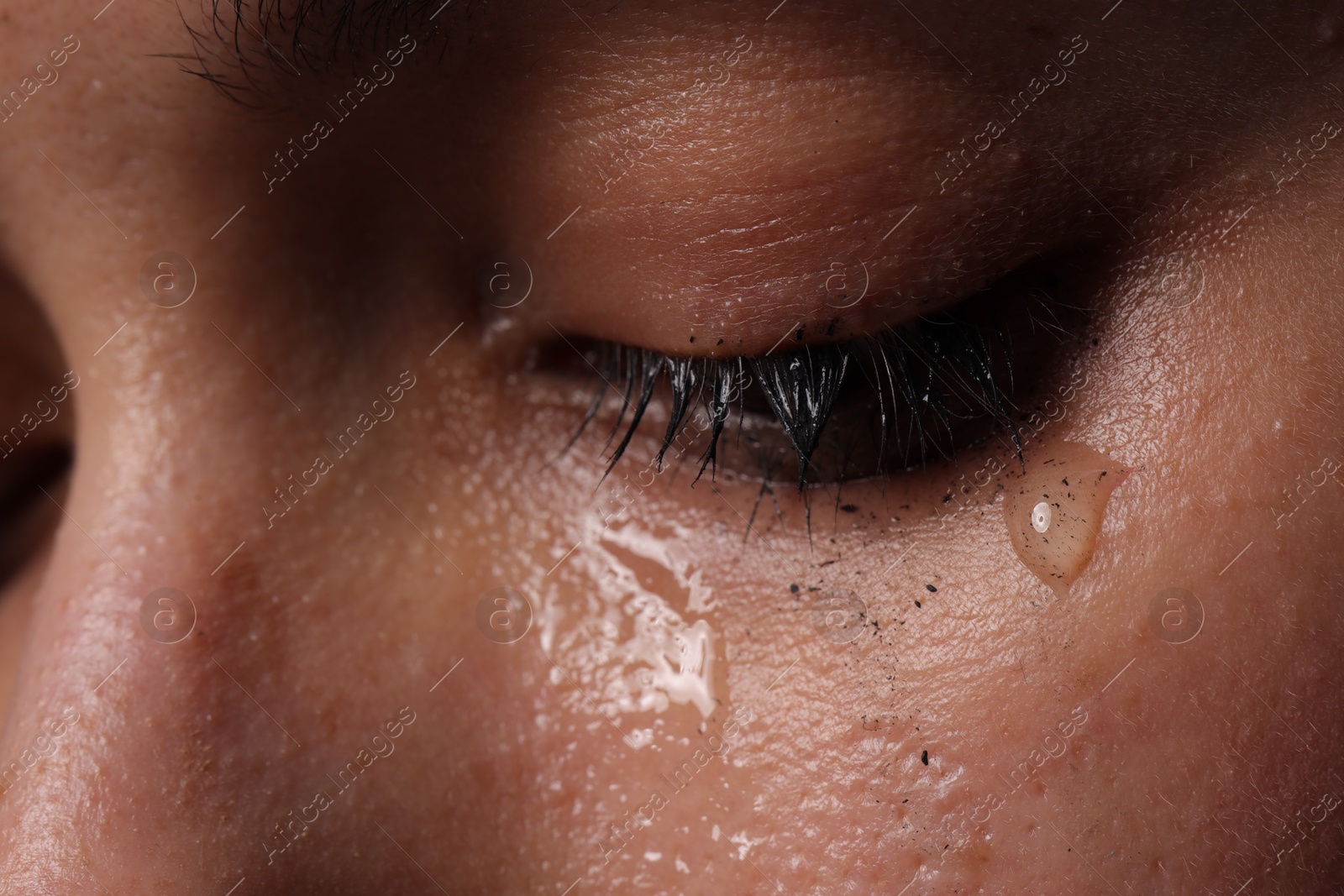 Photo of Closeup view of sad young woman crying