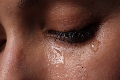 Photo of Closeup view of sad young woman crying
