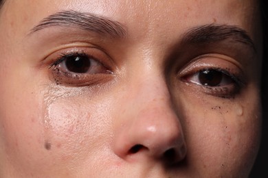Photo of Closeup view of sad young woman crying
