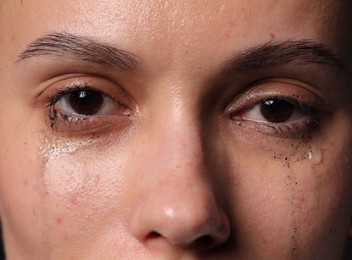 Photo of Closeup view of sad young woman crying