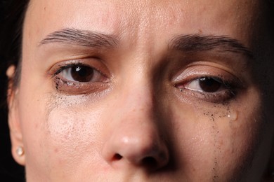 Photo of Closeup view of sad young woman crying