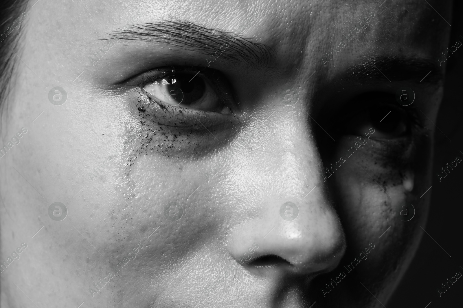 Photo of Sad woman crying on dark background, closeup. Black and white effect