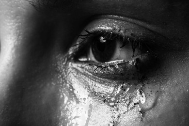Photo of Closeup view of sad young woman crying. Black and white effect