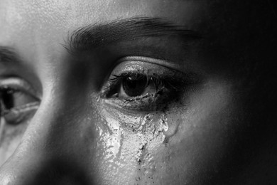 Photo of Closeup view of sad young woman crying. Black and white effect
