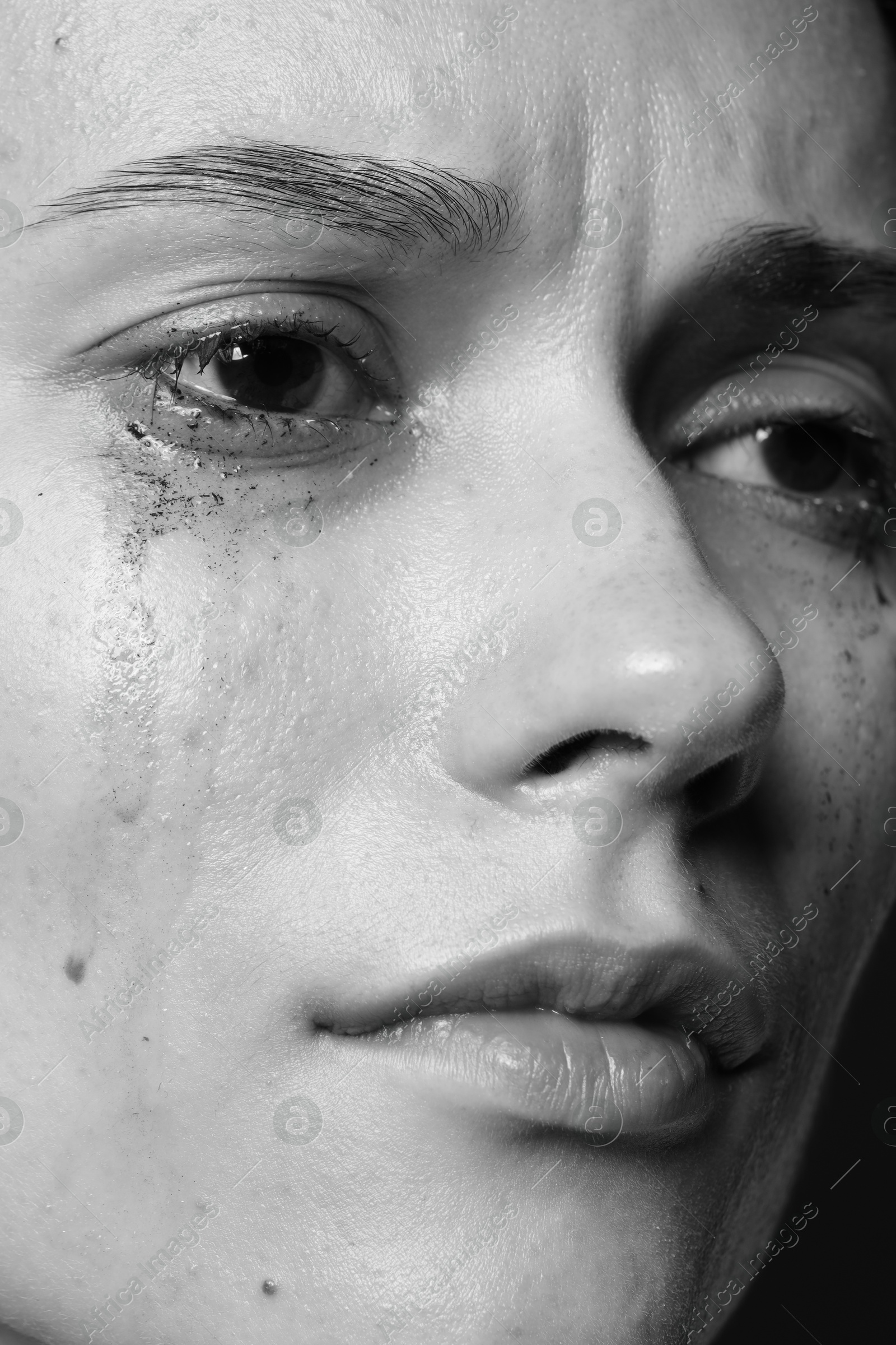 Photo of Closeup view of sad young woman crying. Black and white effect