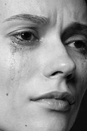 Photo of Closeup view of sad young woman crying. Black and white effect