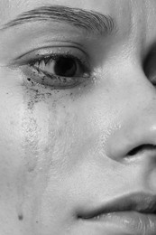 Photo of Closeup view of sad young woman crying. Black and white effect